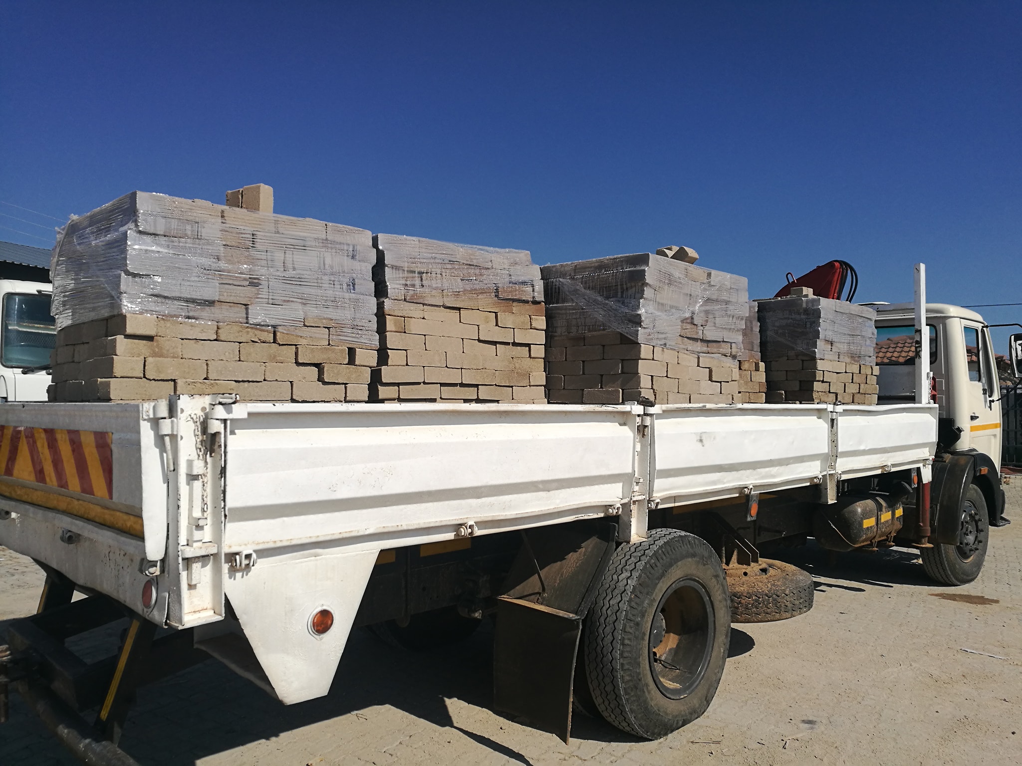 Delivery truck loaded with blocks under a clear blue sky
